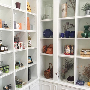 A photo of a corner of a retail establishment, showing shelves with products arranged on them.